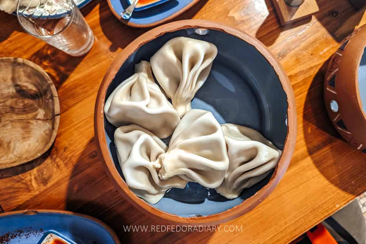 Where to Eat the Best Khinkali in Tbilisi - 2025 Local Guide 15 Traditional Georgian khinkali served in a clay pot at Maspindzelo Express in Tbilisi